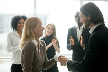 Boss handshaking rewarding motivating successful female employee congratulating with promotion,...