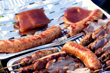 Grilled meat on sticks, sausage and bacon. Family picnic in the open air. Shallow depth of field.