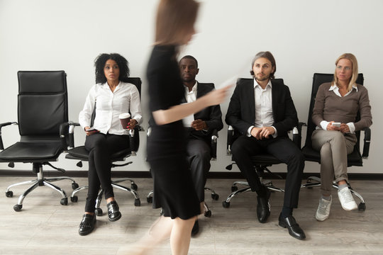 Stressed envious curious applicants preparing for job interview sitting on chairs in queue watching rival going out after meeting waiting for result, human resources rivalry, winner and loser concept