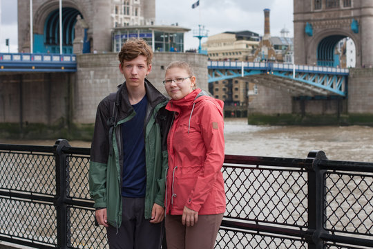 Young couple is standing on embankment of river Thames.