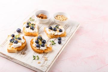 Toast with fresh berries blueberry Ricotta cheese, thyme, honey and hazelnuts, served