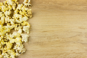 Popcorn on wooden desk. Free space for text