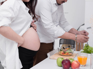 Pregnancy healthy food and people concept.future dad and mom eating healthy salad and take care together.