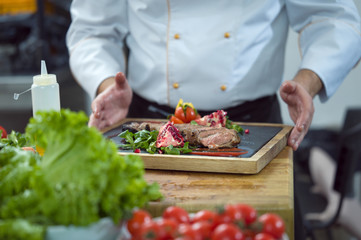 closeup of Chef hands serving beef steak