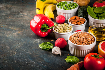 Healthy food background, trendy Alkaline diet products - fruits, vegetables, cereals, nuts. oils, dark blue concrete background copy space