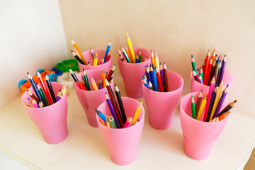 Color pencils in glass on desk with shallow depth of field Pencils in a glass on school desk
