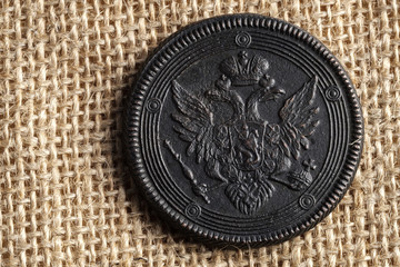 on canvas fabric is an old Russian coin with a double-headed eagle, a copper coin
