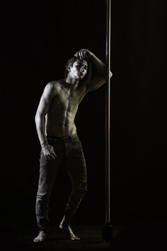 Tired dancer concept. Guy lean on metallic pole.