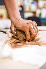 Concepts of Ceramist in Workshop. Closeup of Working  Hands of Male Potter Professional Making a Clay Lump on Workbench in Studio.