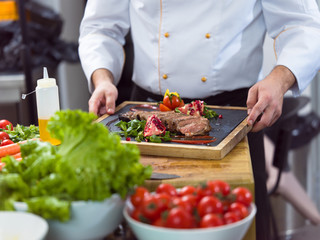 closeup of Chef hands serving beef steak