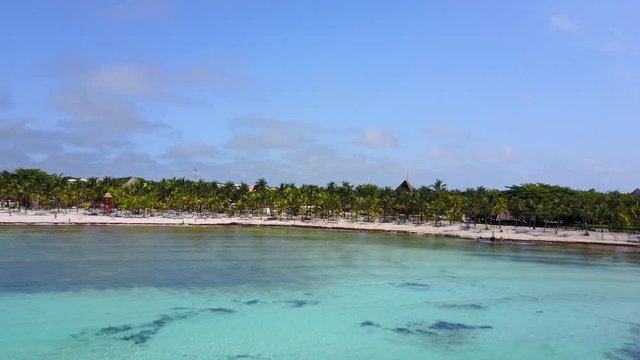 Aerial drone shot. Aerial view from above, birde eye view at an luxury resort hotel beach of a tropical coast. Turquoise water of the Caribbean Sea. Riviera Maya Mexico.