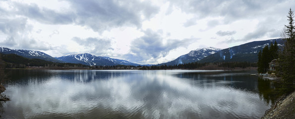 Beautiful mountains view over calm lake and sky reflecting in water, calm vibrant landscape.