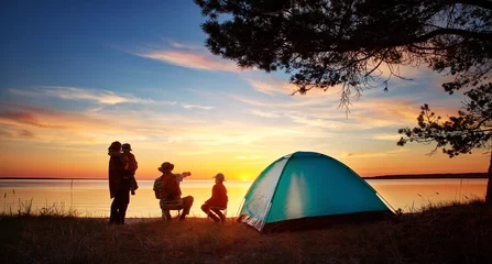 Wall murals Camping Family resting with tent in nature at sunset