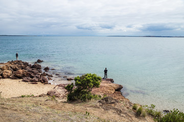 Two fishermen on the rocks at Erehwon Point Beach, Cowes, Phillip Island, Victoria, Australia