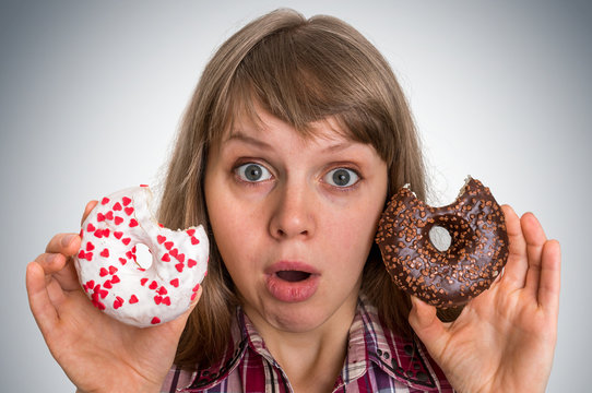Attractive woman is choosing between two donuts