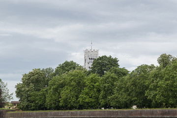 City wall of the Italian city Lucca in Tuscany with trees and the tower of the dome