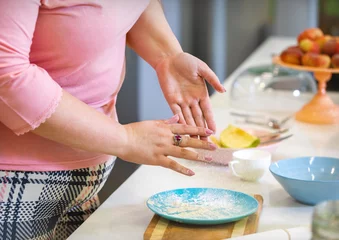 Foto op Canvas woman cleans hands from flour in kitchen © Vladimir Bikhovskiy