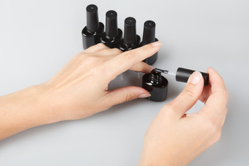 nail care. woman opens a jar of lacquer. 