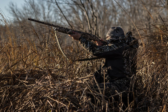 "Open Fire" - On a freezing morning in Canada, a duck hunter aims for an incoming flight of ducks.
