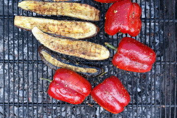 Close-up red pepper and slices of eggplant are grilled. Open fire kitchen. BBQ Restaurant. Red grilled pepper on bbq fireplace