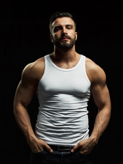 A strong, a serious, muscular man in a white t-shirt is worth and looks in camera. He's got the beard on the face and different emotions - 204819740