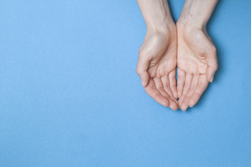 Empty palms up isolated on a blue background. Copy space.