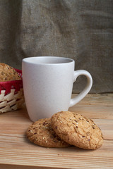 Oatmeal cookies with sunflower seeds near cup of tea.