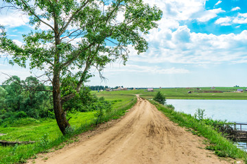 Pond and trees growing along a dam in rural areas in Udmurtia, in Russia