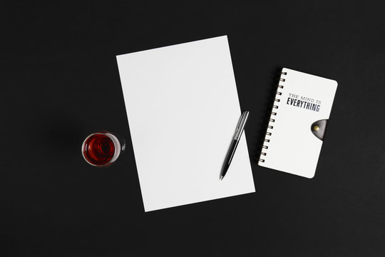 Blank white paper, wine and diary on black background. - Powered by Adobe
