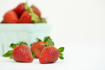 Freshly Picked Strawberries in Green Glass Produce Carton on White Tabletop