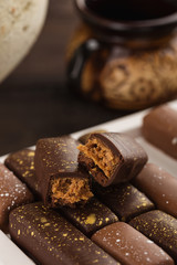 chocolate candies with salt caramel decorated with golden splashes. handmade bonbons on wooden background
