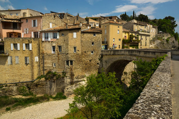 Fototapeta na wymiar Old medieval part of the French Vaison-la-Romaine city with old roman bridge in a foreground.