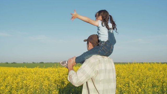 Child with dad in nature. Happy daughter with father in the field. Father circling the child.