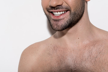 Obraz premium Healthy smile. Close-up of mouth of cheerful young bristled topless guy. He is demonstrating his white teeth. Beauty concept