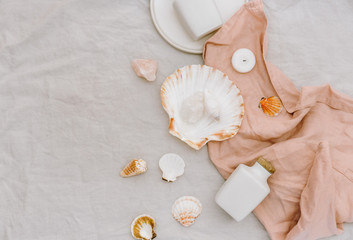 Flat lay sea shells with bottle on linen background