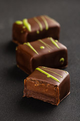 Cut chocolate praline candy on black background