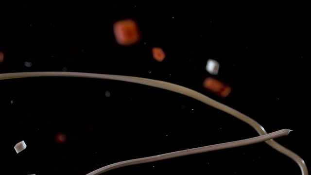 A jet of mayonnaise flies against a background of falling vegetables.