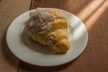 croissant dish on white ceramic plate in hotel cafe