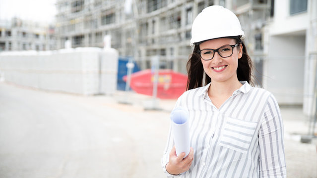 Architektin mit Pl&auml;nen auf einer Baustelle 
