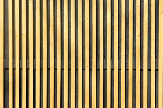 Wall of thin wooden slats. Vertical parallel plates. - Powered by Adobe