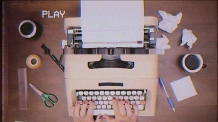 VHS tape: a woman typing (writing text words) on an old vintage mechanical typewriter (now rediscovered by hipsters). View from above, desk filled with tools and a cup of coffee.
