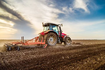 Photo sur Plexiglas Tracteur Tracteur cultivant le champ au printemps