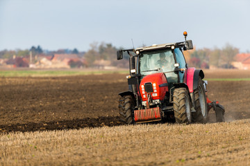 Obraz premium Farmer plowing stubble field