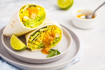 Healthy vegan wraps (burrito) with bulgur, curry sauce and baked tofu. Healthy vegetarian food concept.