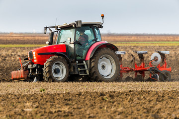 Farmer plowing stubble field