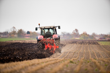 Farmer plowing stubble field