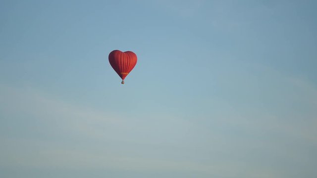 Hot air balloon shape of a heart in the blue sky. Aerostat, Airship. Red balloon.4k