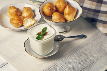 Breakfast with homemade yogurt and profiteroles on a white tablecloth background in the morning.