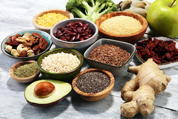superfood concept on white table with avocado, goji and nuts and seeds.