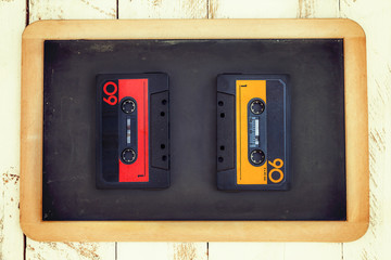 pair of vintage audio cassettes over a black chalkboard
